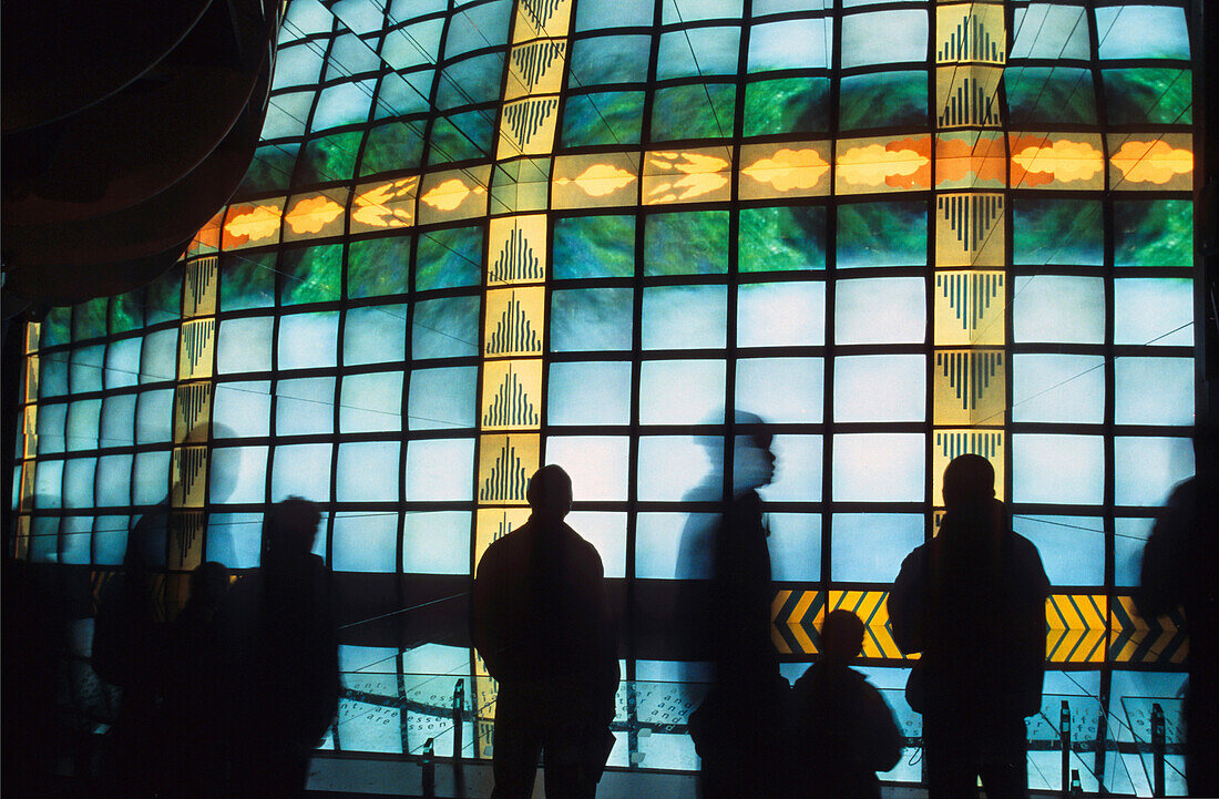 Menschen stehen vor einer Wand mit Bildschirmen im Naturkundemuseum, London, England, Großbritannien