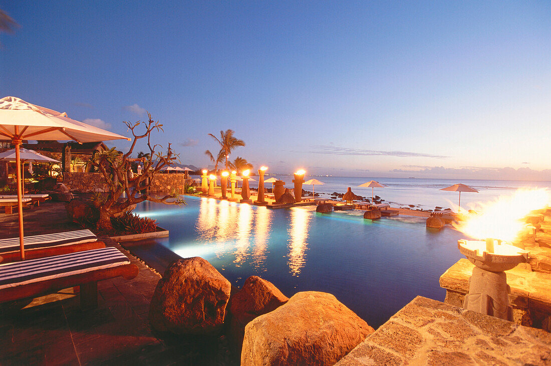 Fackeln erhellen am Abend den Pool des Hotel Oberoi, Mauritius