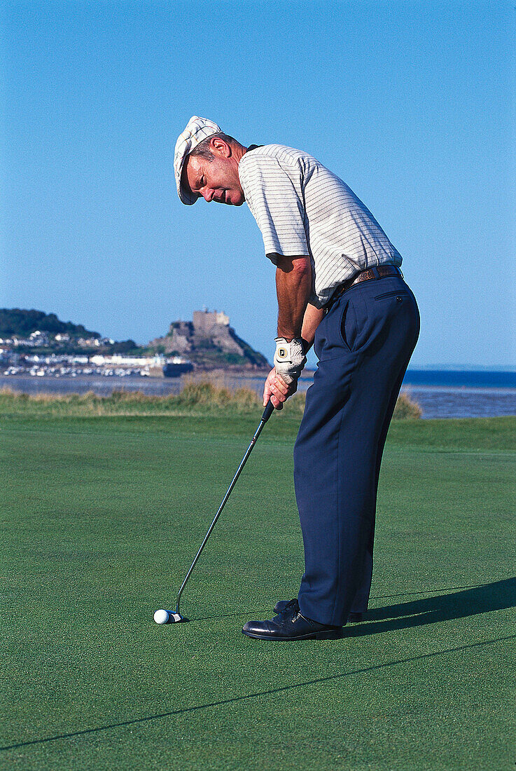 Mann spielt Golf, Schloss Orgeuil im Hintergrund, Jersey, Kanalinseln, Großbritannien, Europa