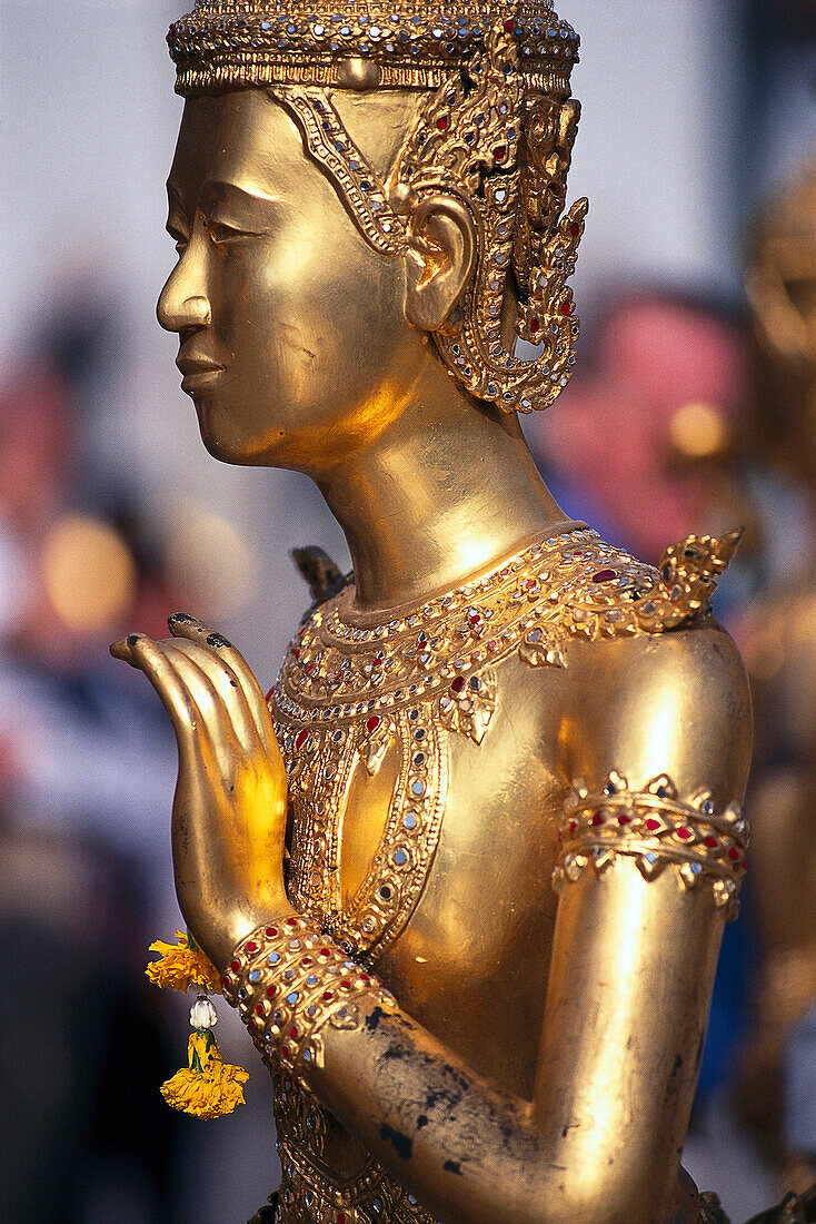 Side view of a golden statue at the temple Grand Palace, Bangkok, Thailand