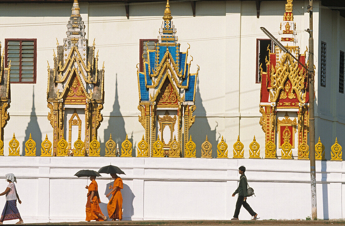 Menschen vor der Tempelanlage Wat Luang im Sonnenlicht, Pakse, Laos