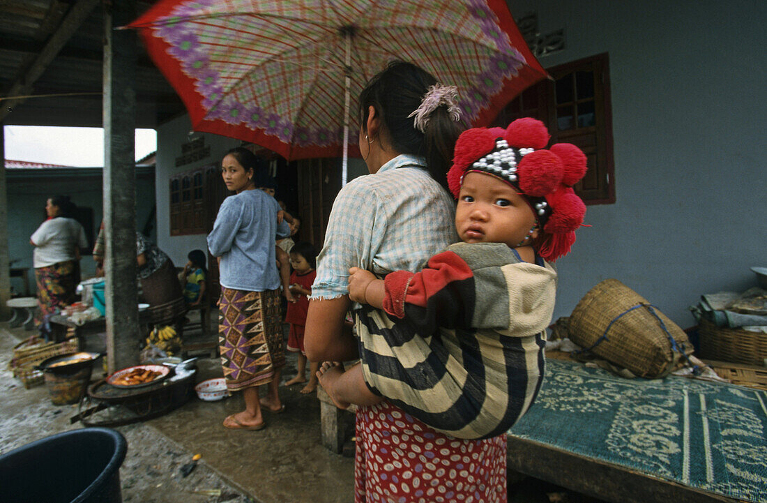 Dorfbewohner, Frau trägt ein Kind auf dem Rücken, Ban Phan Tang, Laos