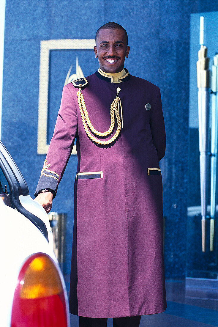 Lächelnder Türsteher vor dem Hotel Burj Al Arab, Dubai, V.A.E., Vereinigte Arabische Emirate, Vorderasien, Asien