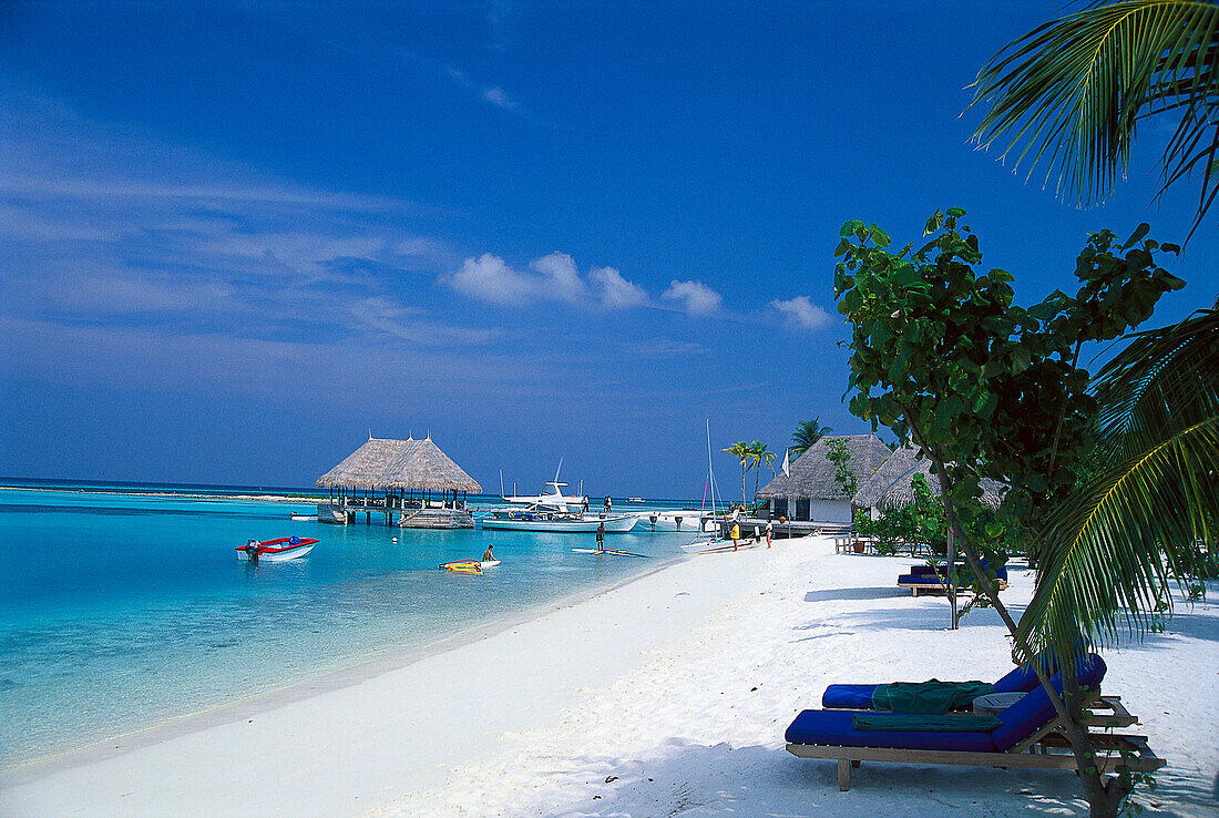 Hütten und Palmenstrand im Sonnenlicht, Four Seasons Resort, Kuda Hurra, Malediven, Indischer Ozean