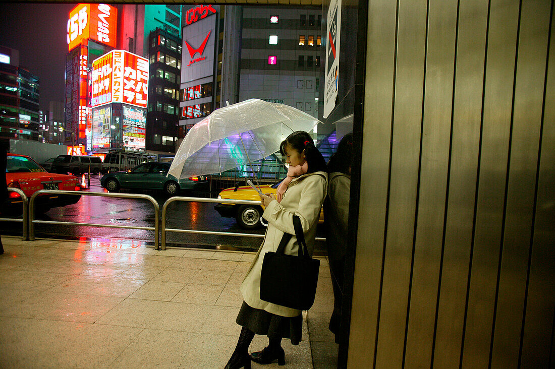 Girl with mobile phone, Shinjuku station Tokyo, Japan