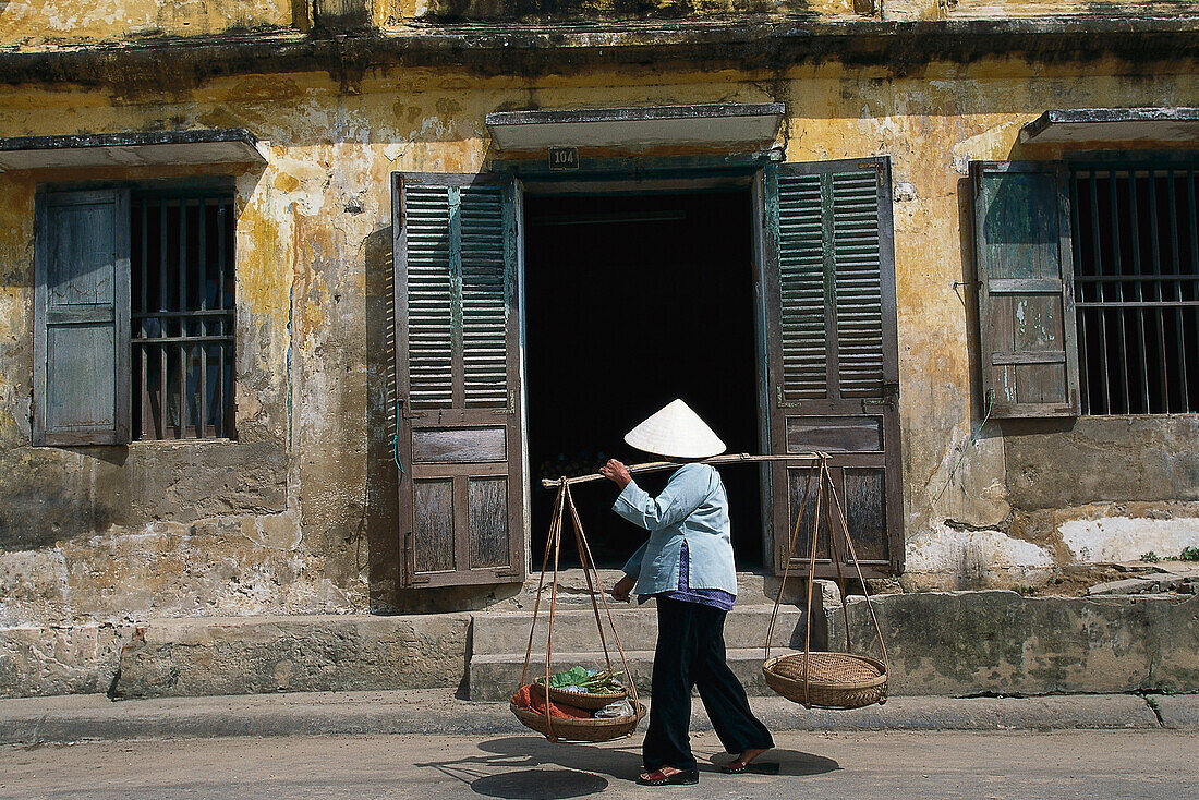Frau trägt Körbe in Da Nang, Vietnam