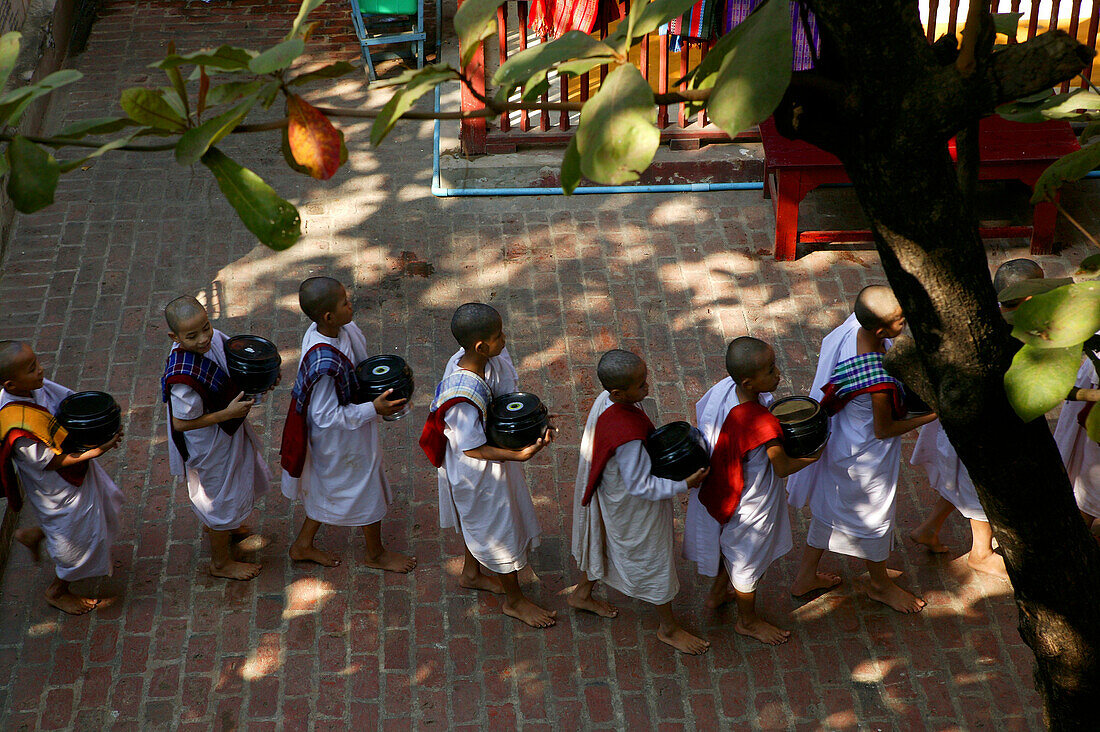 line of young nuns going into the dining hall of monastery, Myanmar