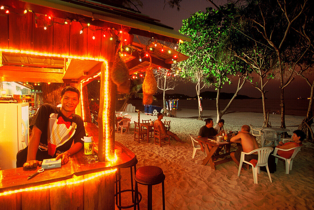 Menschen sitzen vor einer Strandbar am Patong Strand, Phuket, Thailand