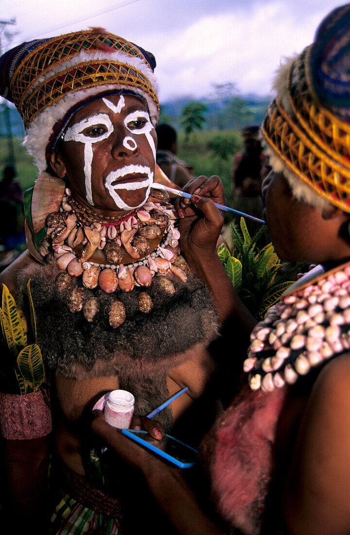 Woman painting the face of another woman in preparation for the Huli Sing Sing celebrations, Mt Hagen, Eastern Highlands, Papua New Guinea, Melanesia
