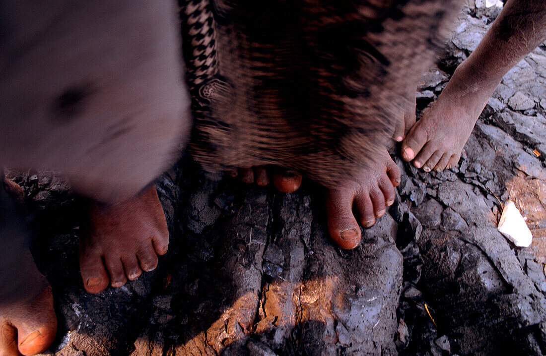 Children's bare feet standing on solidified lava, Goma, Congo, Africa