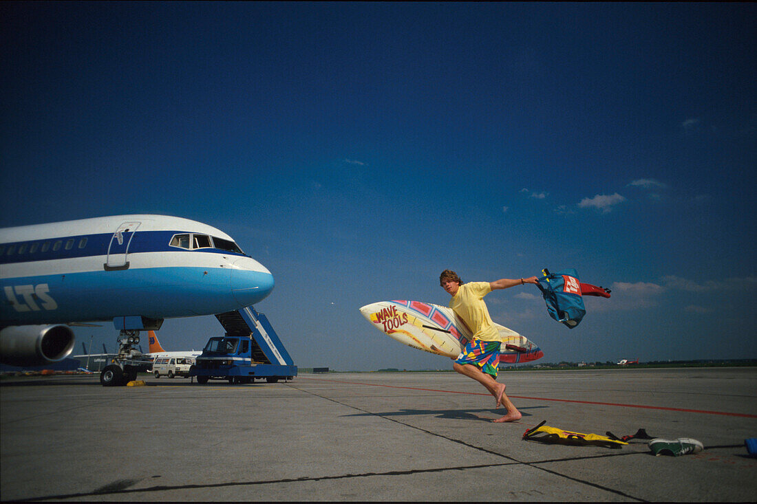 Lastminute, Surfer eilt zum Flugzeug, Flugplatz, Muenchen Bayern, Deutschland