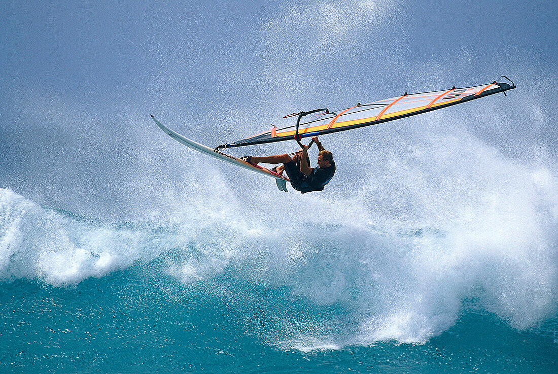 Ein Mann mit Windsurfbrett im Sprung, Hawaii, USA, Amerika