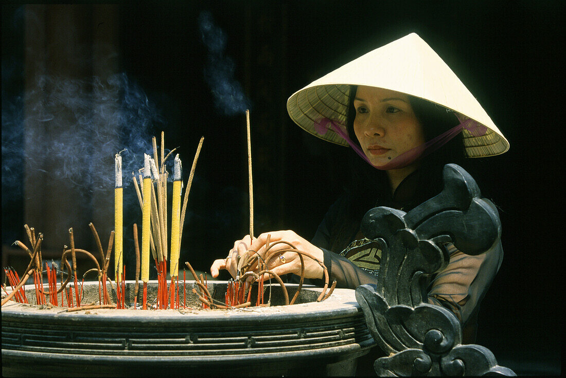Frau mit Räucherstäbchen im Dai Hung Tempel, Hue, Vietnam, Asien