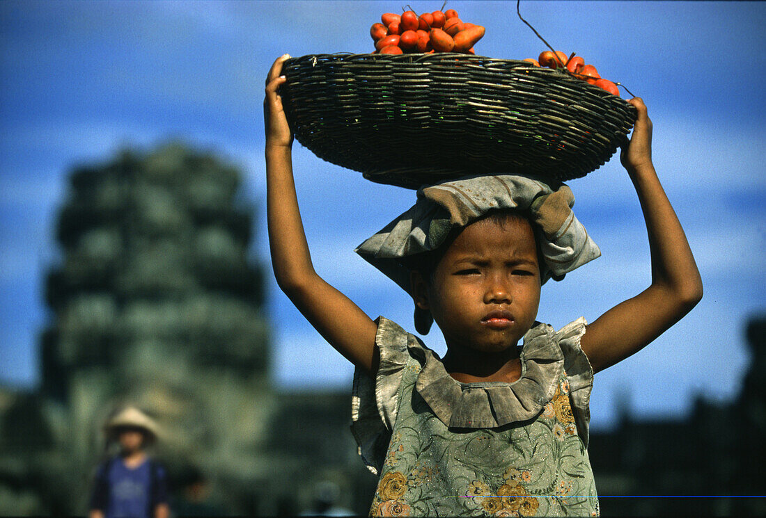 Mädchen trägt einen Korb mit Früchten auf ihrem Kopf, Angkor Wat, Siem Raep, Kambodscha, Asien
