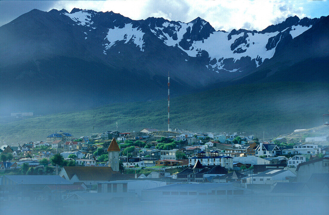 Stadt im Nebel vor schneebedeckten Bergen, Ushuaia, Argentinien, Südamerika, Amerika