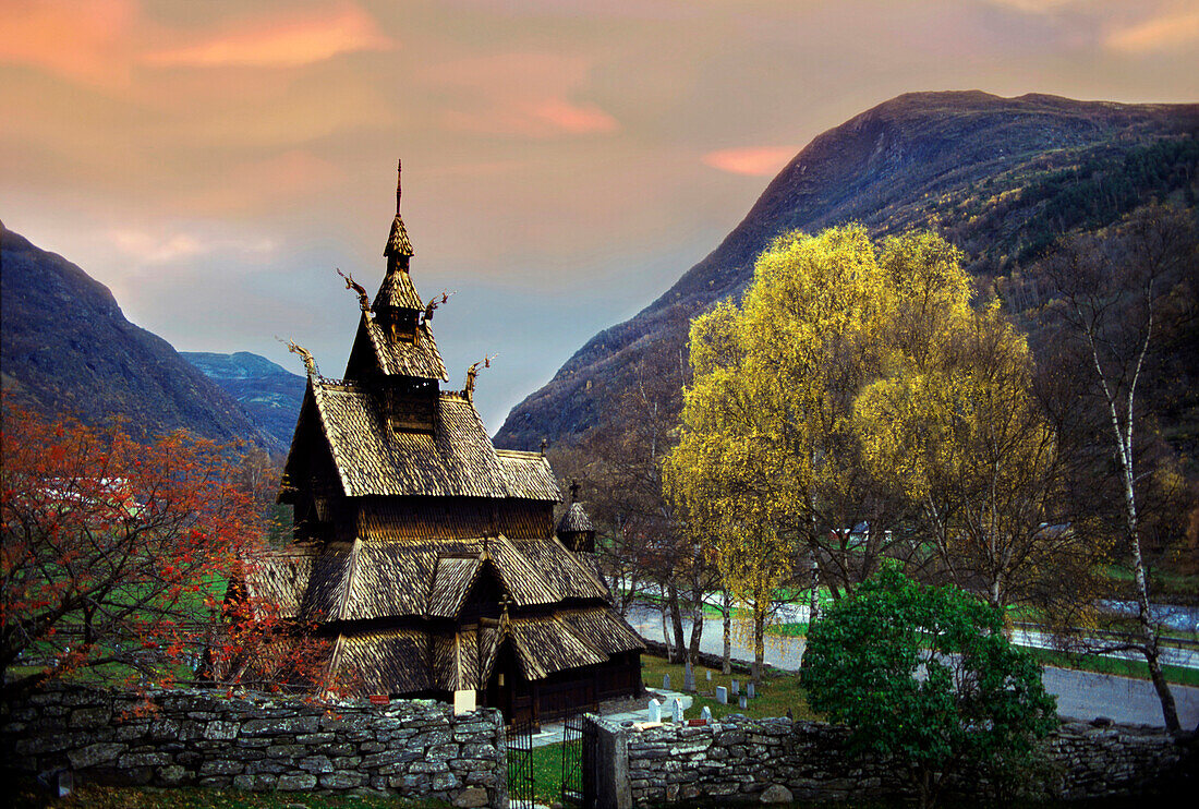 Stabkirche zwischen Bergen und Bäumen am Abend, Norwegen, Skandinavien, Europa