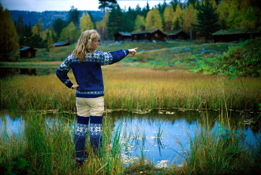 Norwegische Frau steht vor einem Teich, Maihaugen, Lillehammer, Norwegen, Skandinavien, Europa