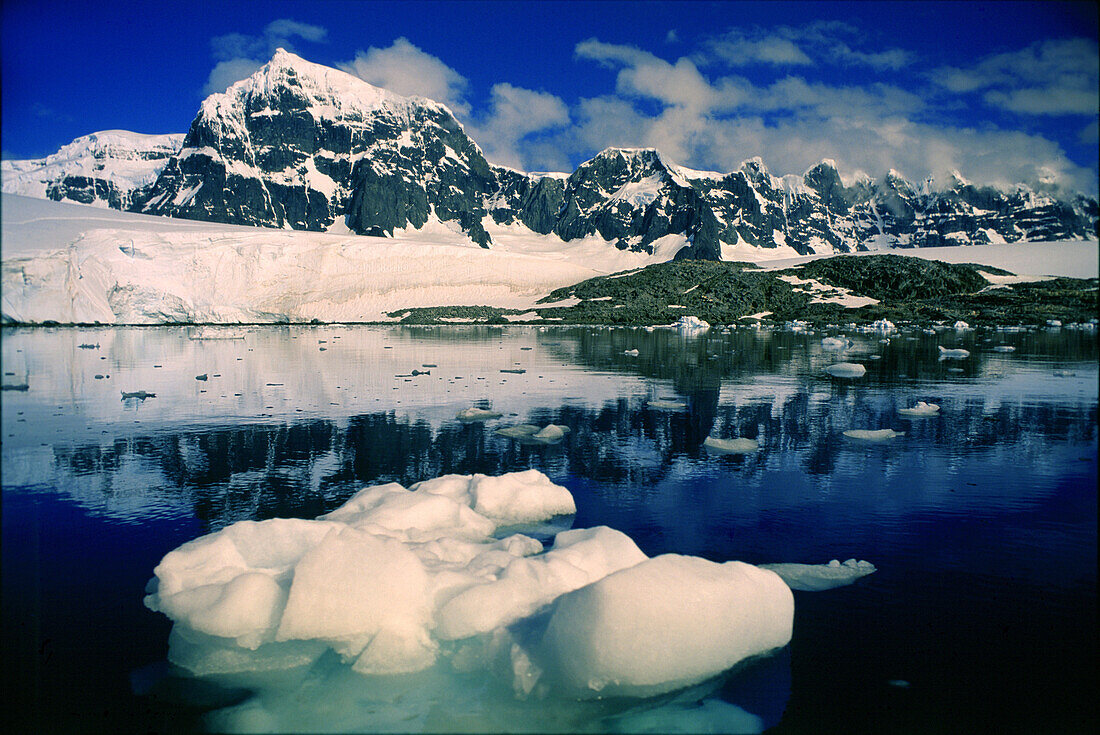 Blick auf Eisscholle und schneebedecktes Gebirge, Port Lockroy, Antarktische Halbinsel, Antarktis