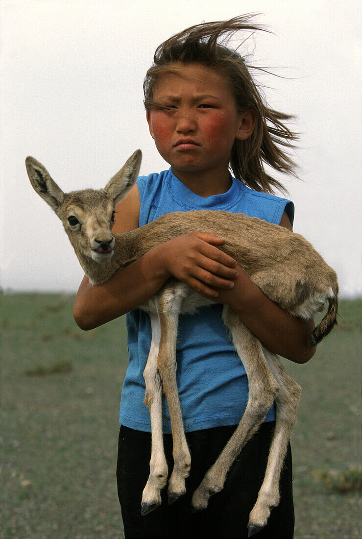 Girl with orphaned gazelle, Gobi Desert, Mongolia, Asia