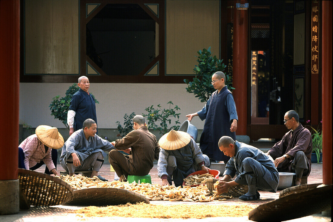 Monks and nuns with harvest at the inner courtyard of a monastery, Tainan, Taiwan, Asia