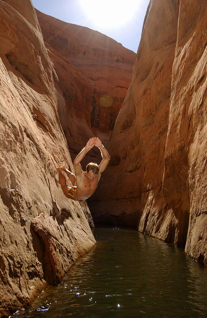 Mann springt von der Klippe, Klippenspringen, Lake Powell, Secret Canyon, Lake Powell, Utah, Arizona, USA