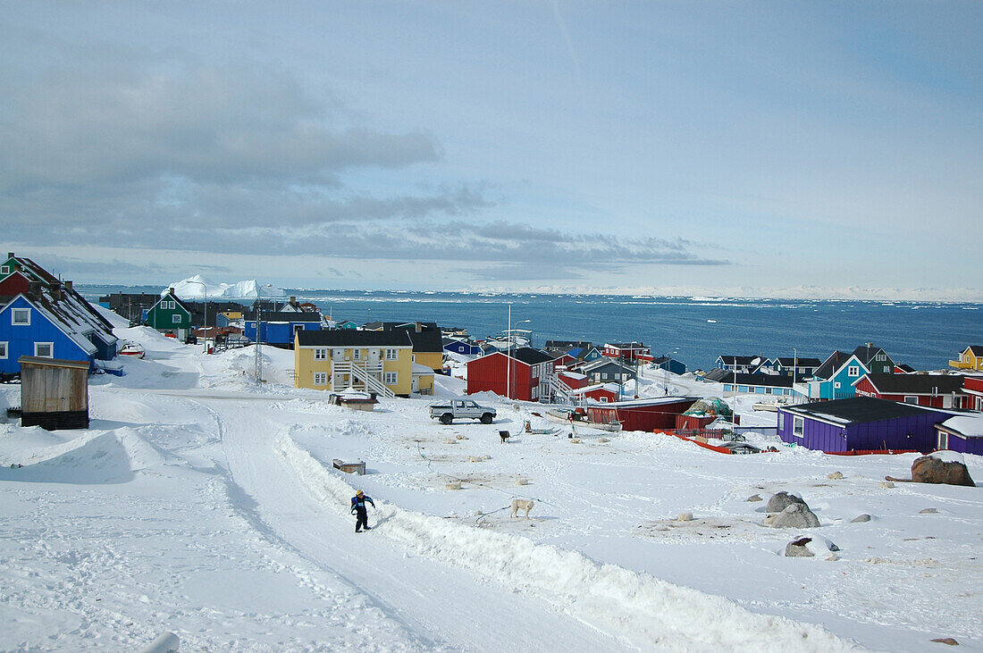 Blick auf ein verschneites Dorf am Wasser, Ilulissat, Grönland