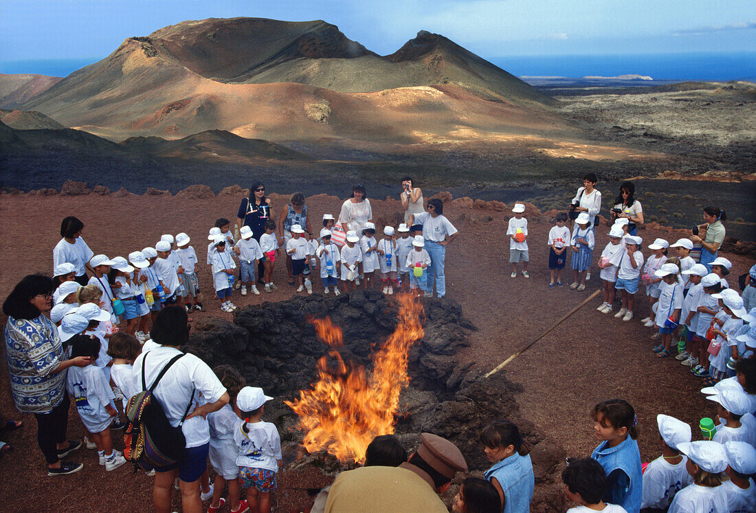 School class gathering around a fire, Timanfaya National Park, Lanzarote, Canary Islands, Spain, Europe