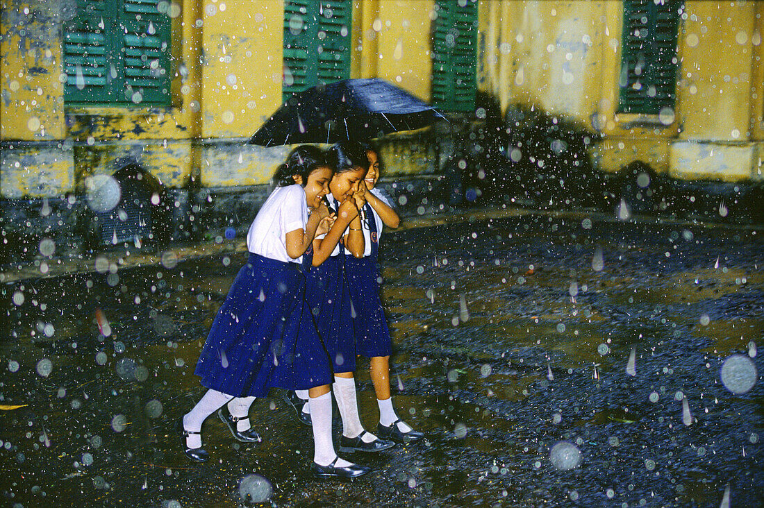 Schoolgirls in monsoon shower, Calcutta, West Bengal India, Asia