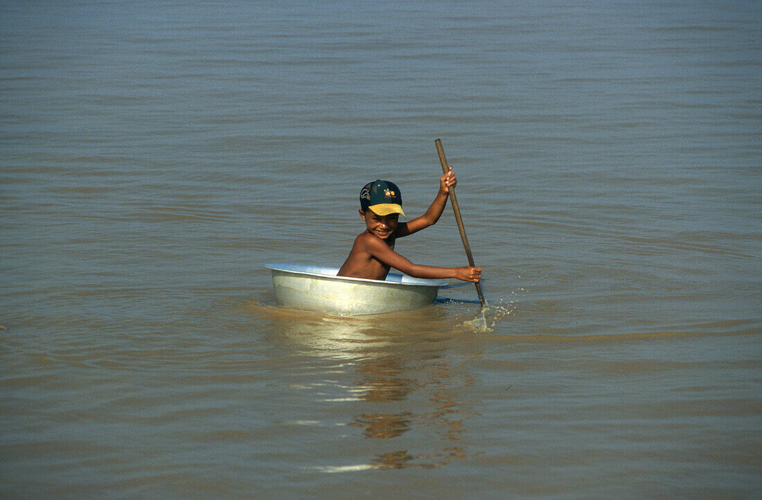 Tonle Sap lake, boy paddling in a tub, Siem Raep, Cambodia Asia