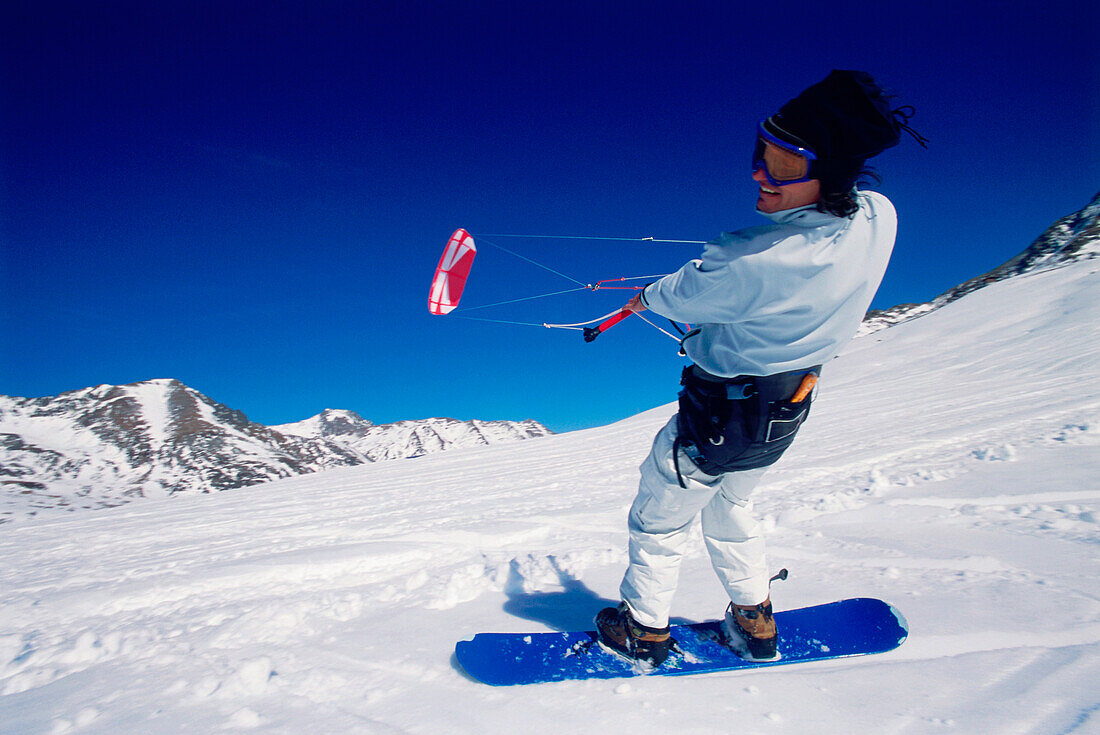 Man kiteboarding in snow, Lermoos, Lechtaler Alpen, Tyrol, Austria