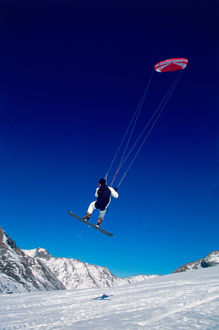 Man kiteboarding in snow, Lermoos, Lechtaler Alpen, Tyrol, Austria