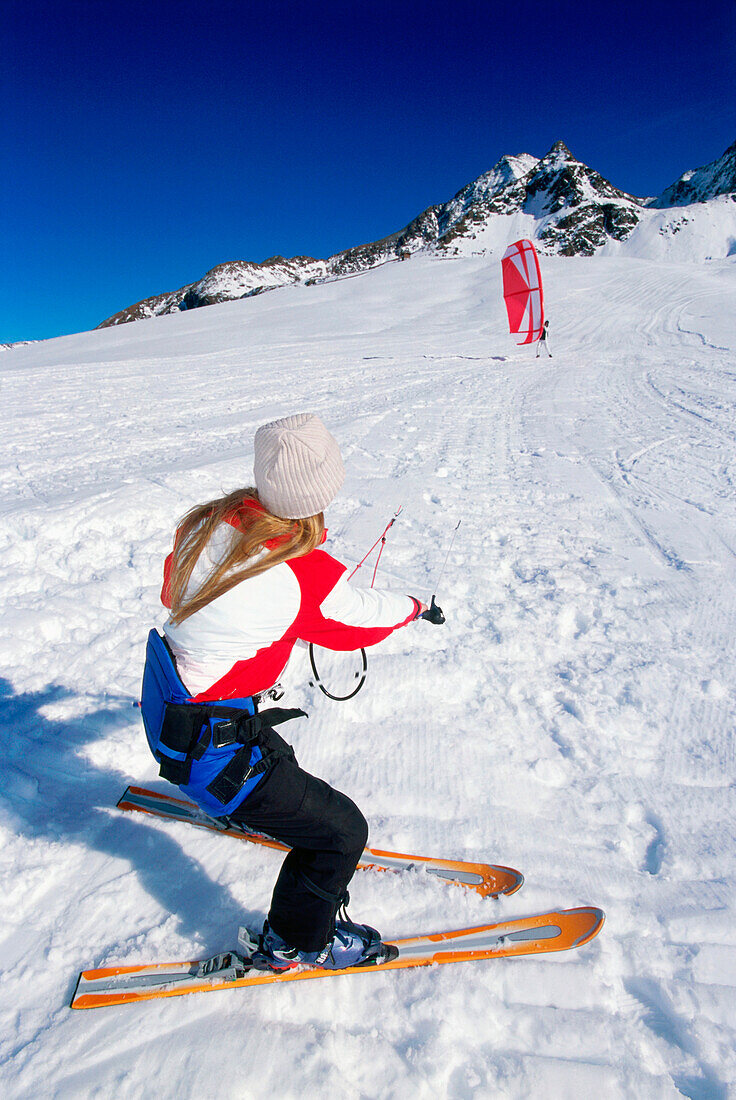 Young woman starting kiteboard in snow, Lermoos, Lechtaler Alpen, Tyrol, Austria