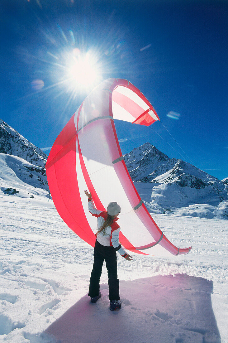 Junge Frau hält Snowkite, Lermoos, Lechtaler Alpen, Tirol, Österreich