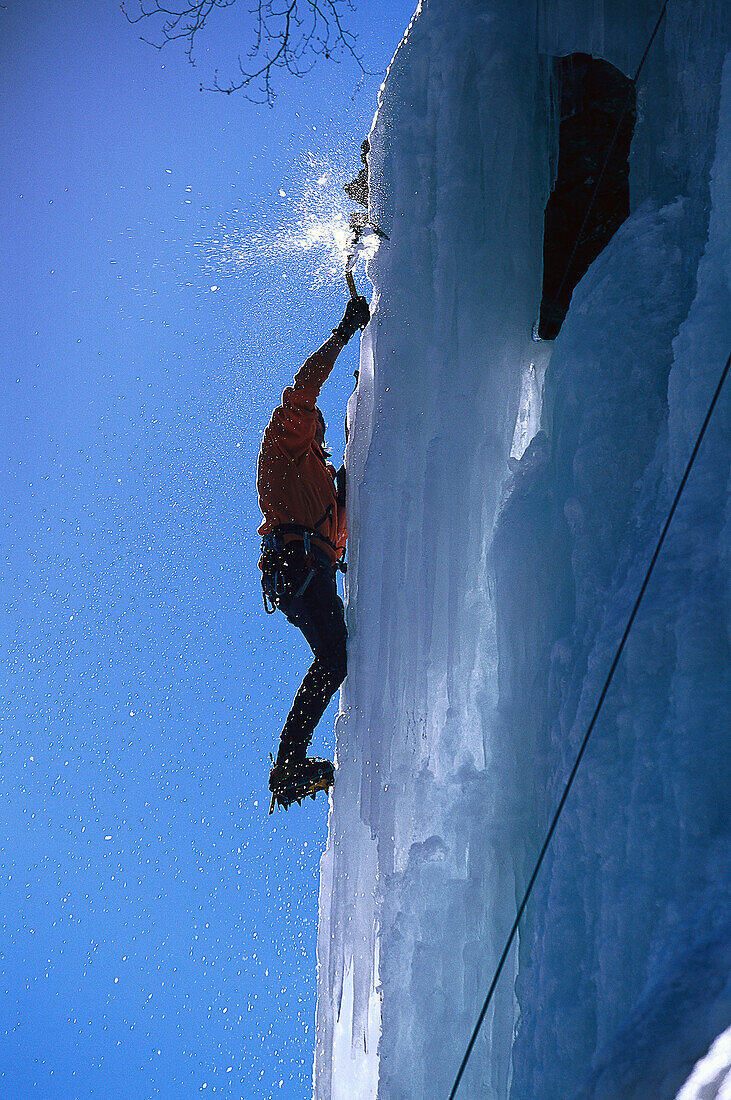 Ein Mann klettert an einer Eiswand hoch