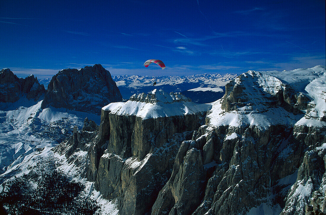 Paraglider over mountain tops, Sella Ronda, Dolomites, Alto Adige, Italy