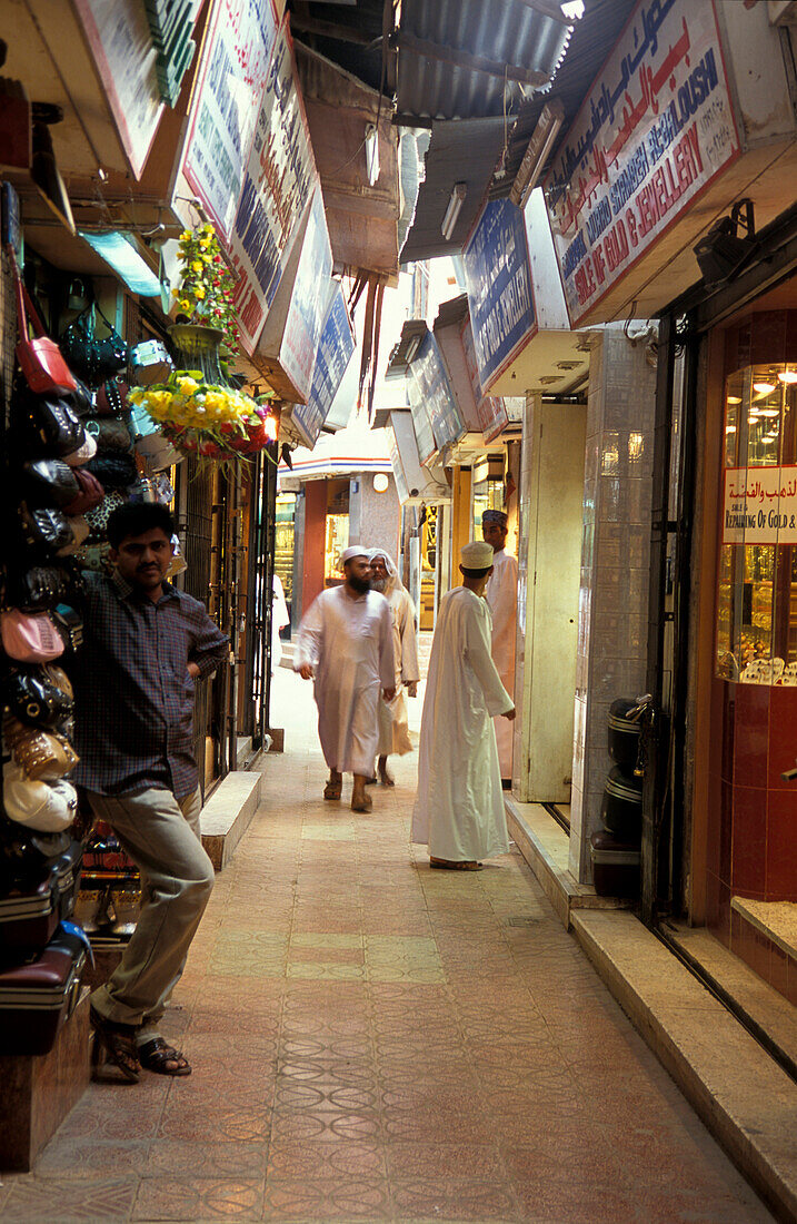 Menschen gehen durch schmale Gasse zwischen Geschäften, Souk, Maskat, Oman
