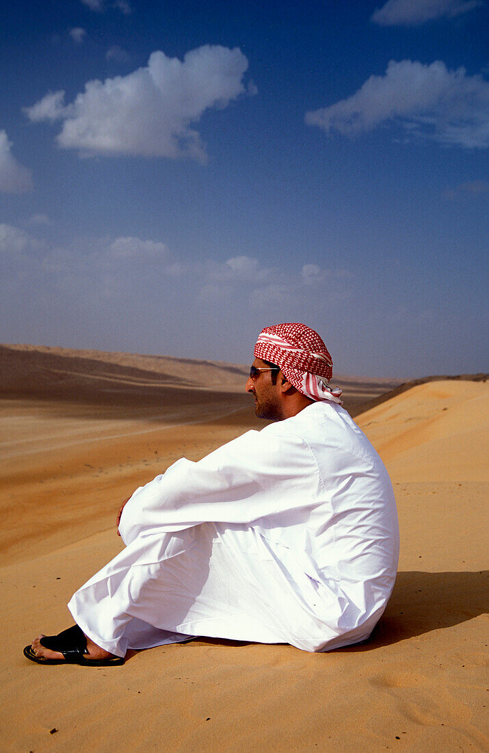 Man sitting in the sand at the desert, Sultanat Oman, Middle East, Asia
