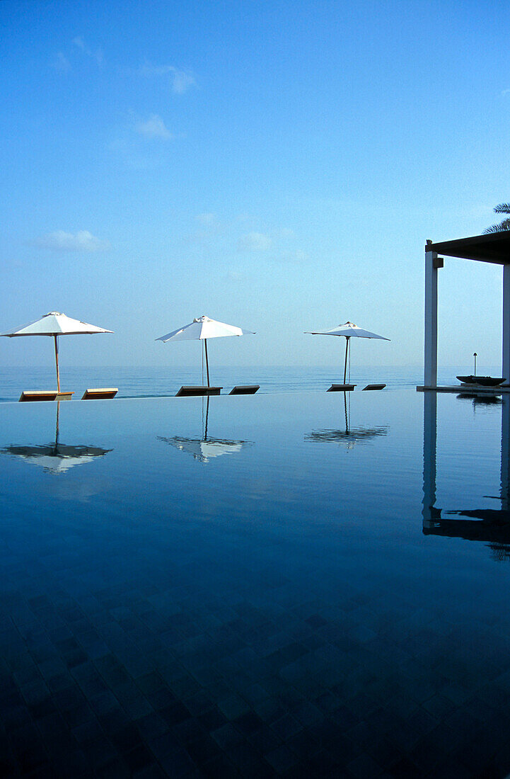 Sonnenschirme zwischen Pool und Meer, The Chedi Hotel, Maskat, Oman