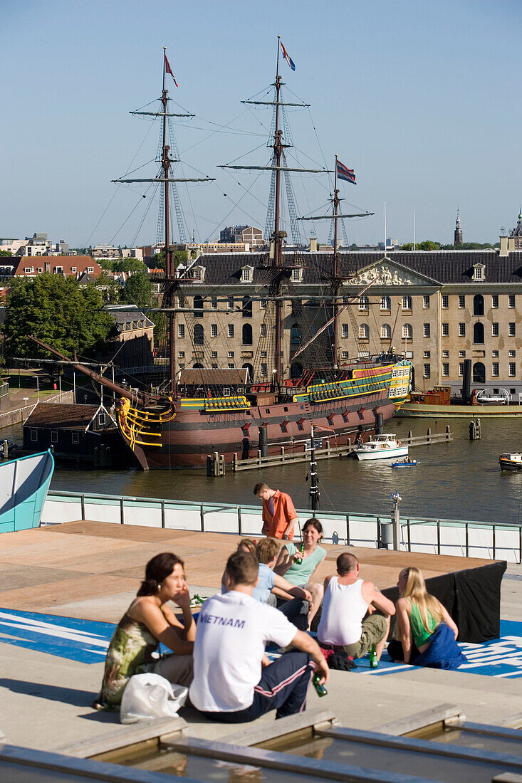 People, Sailing Boat, Terrace Cafe, People on Terrace Cafe of NEMO Center looking to Nederlands Scheepvaartmuseum with replica sailer Amsterdam, Amsterdam, Holland, Netherlands