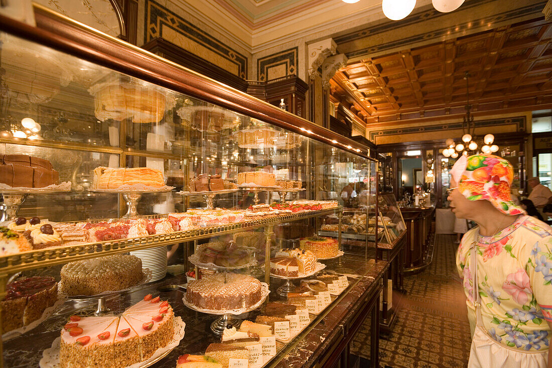 Woman see into outlay full with fancy cakes, Cafe Demel, Vienna, Austria