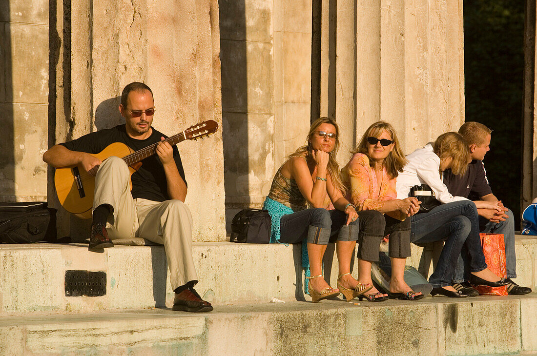 People sitting on stairs of Theseus Temple at Volksgarten, Vienna, Austria