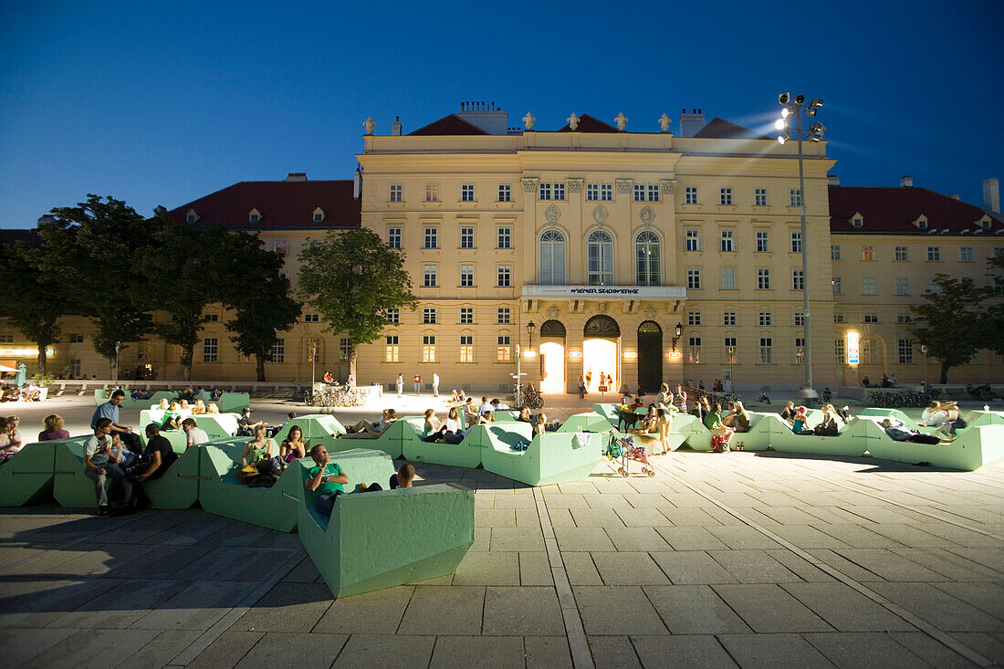 People sitting in seatings in front of the former imperial stables at MuseumsQuartier, Vienna, Austria