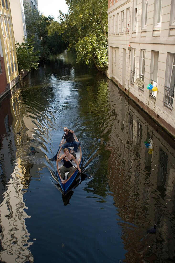 Couple canoeing on a loading canal, Couple canoeing on a loading canal of the lake Alster, Hamburg, Germany