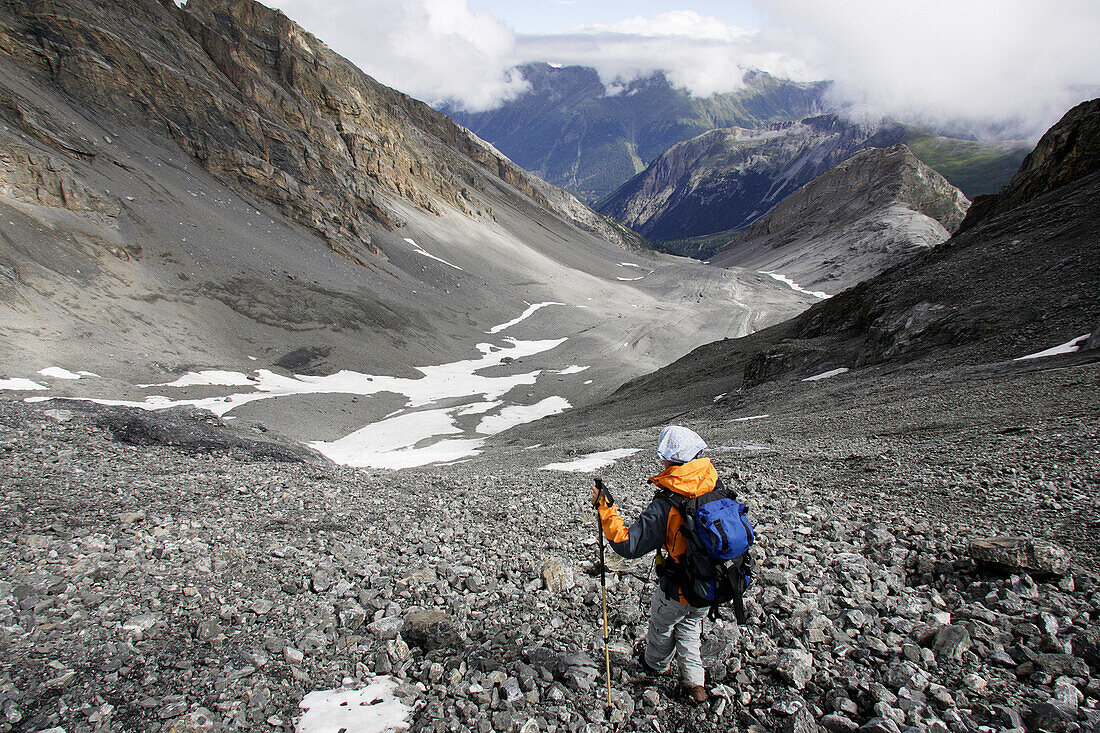 Eine Frau beim Abstieg über ein Geröllfeld, Piz Quattervals, Valetta, Schweizer Nationalpark, Engadin, Graubuenden, Graubünden, Schweiz, Alpen