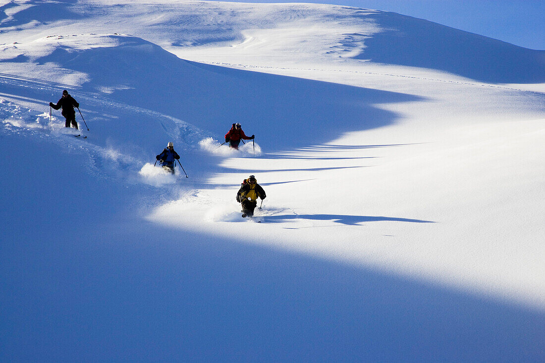 Small group of skiers descending a mountain on powder snow, Safiental, Graubuenden, Grisons, Switzerland, Alps