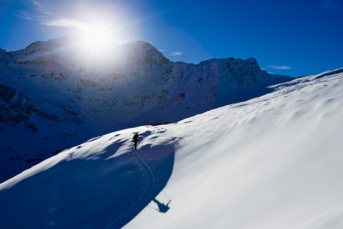 One skialpinist ascending snowy mountain, Safiental, Grisons, Graubuenden, Switzerland, Alps