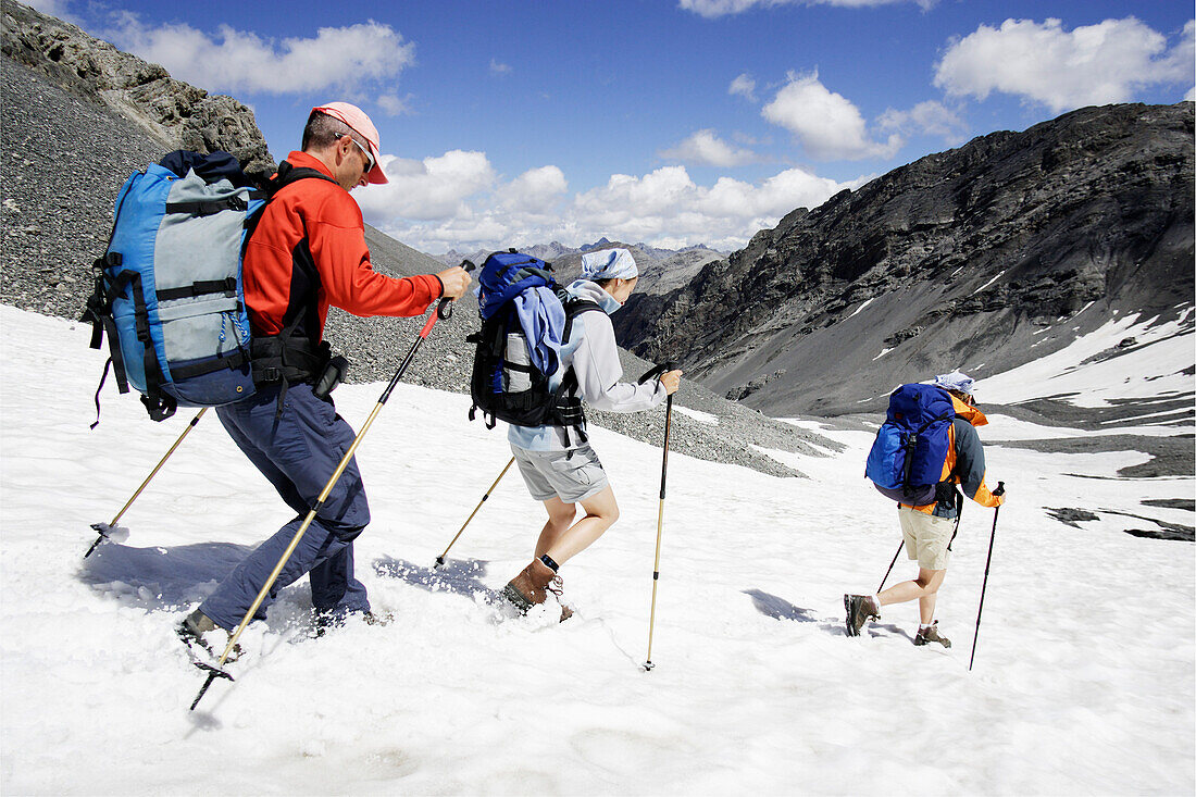 Wanderer rennen über ein Schneefeld hinunter, Val Sassa, Schweizer Nationalpark, Engadin, Graubuenden, Graubünden, Schweiz, Alpen