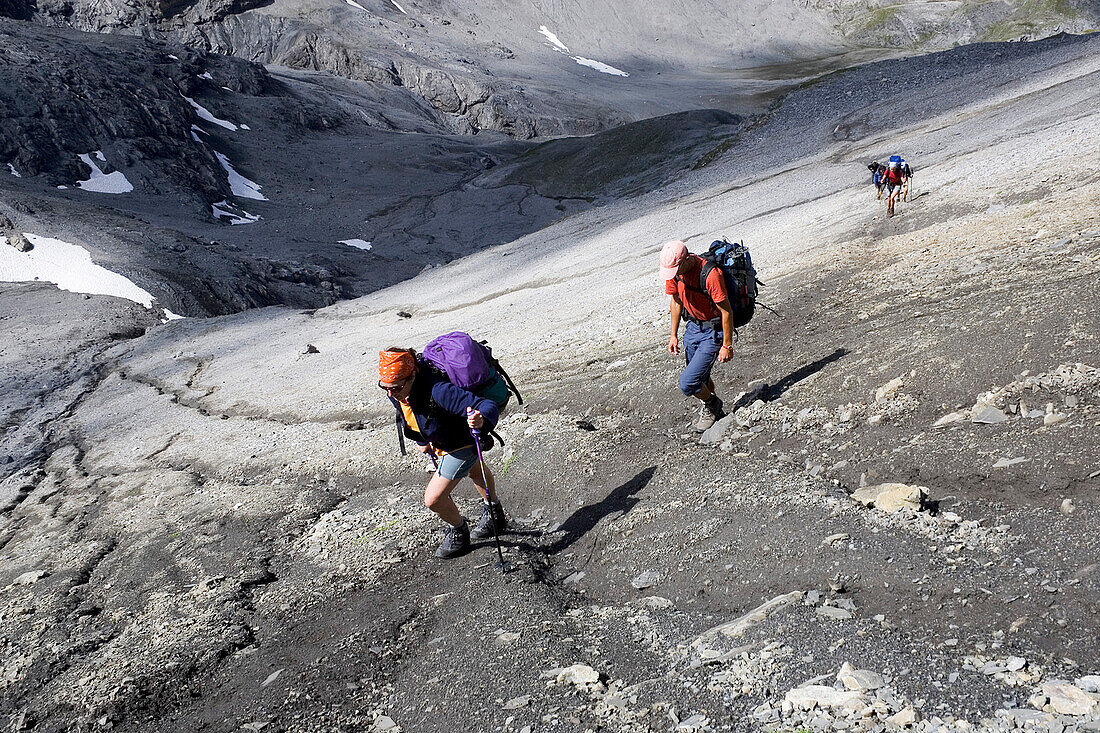 Group of hikers on a remote path in the mountains, Val Mueschauns, Fuorcla Val Sassa, Swiss Nationalpark, Engadin, Graubuenden, Grisons, Switzerland, Alps