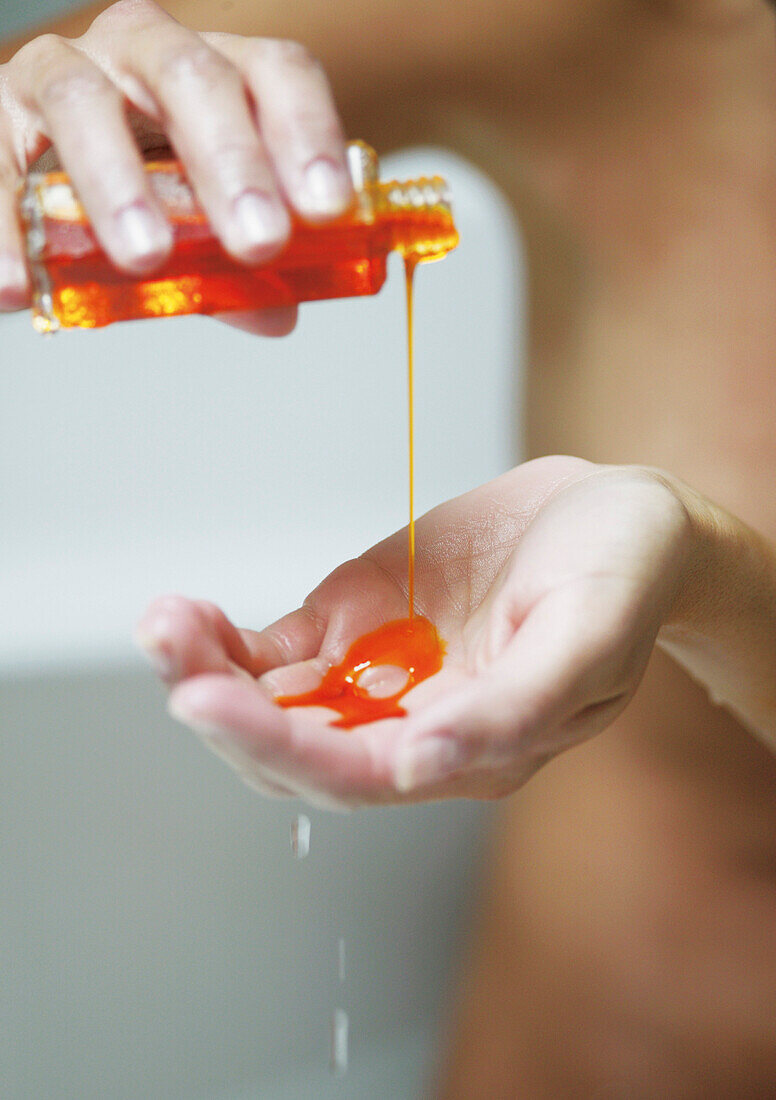 Young woman with body oil on hands