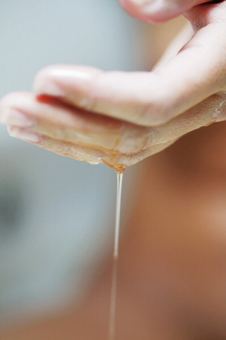 Young woman with body oil on hands